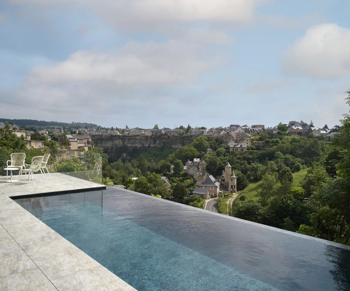 Piscine à débordement avec terrasse minérale