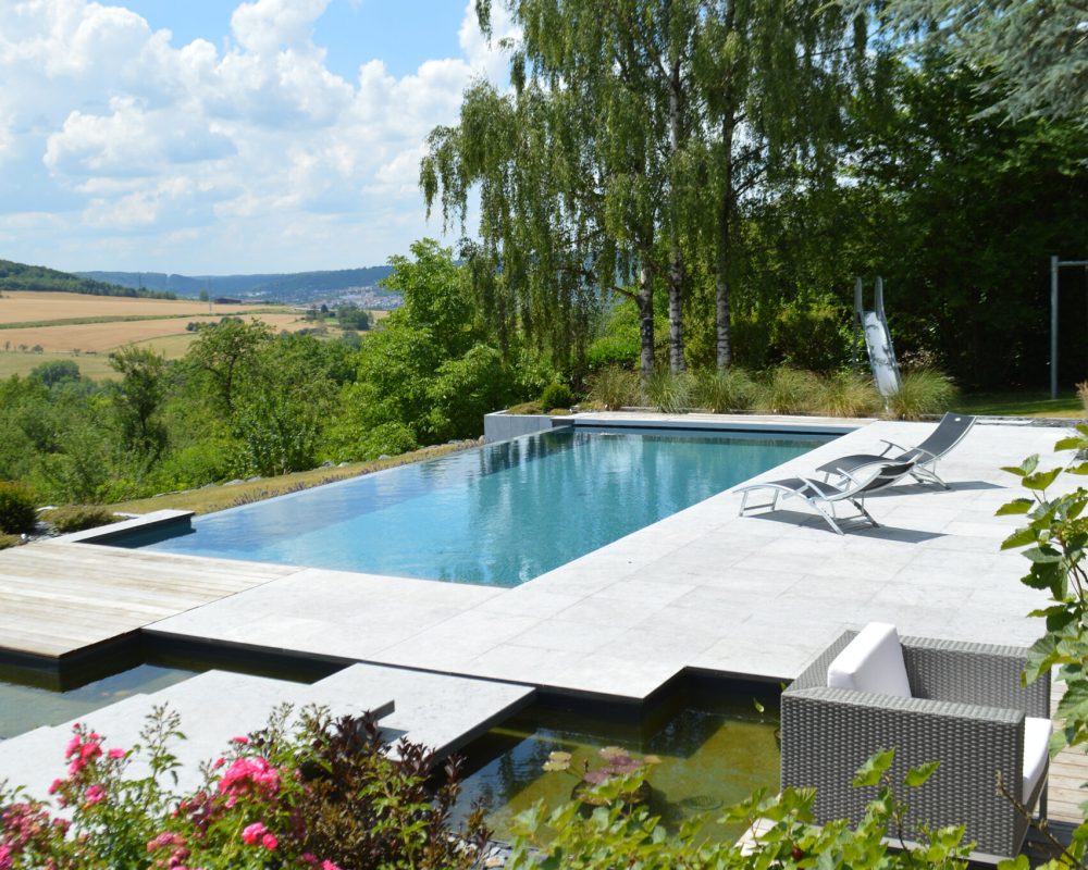 Piscine à débordement 11m x 5m x1.50m avec volet immergé et escalier plage toute largeur Plages en pierres naturelles et bois exotique