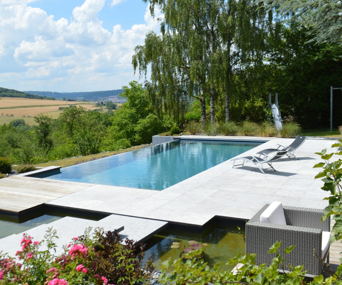 Piscine à débordement 11m x 5m x1.50m avec volet immergé et escalier plage toute largeur Plages en pierres naturelles et bois exotique