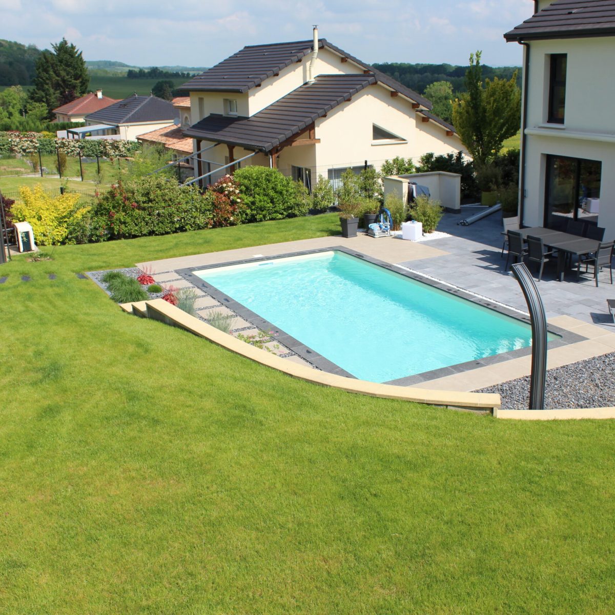 Piscine extérieure avec douche en continuité d'une terrasse en pierre naturelle - Qualité Spa & Piscine