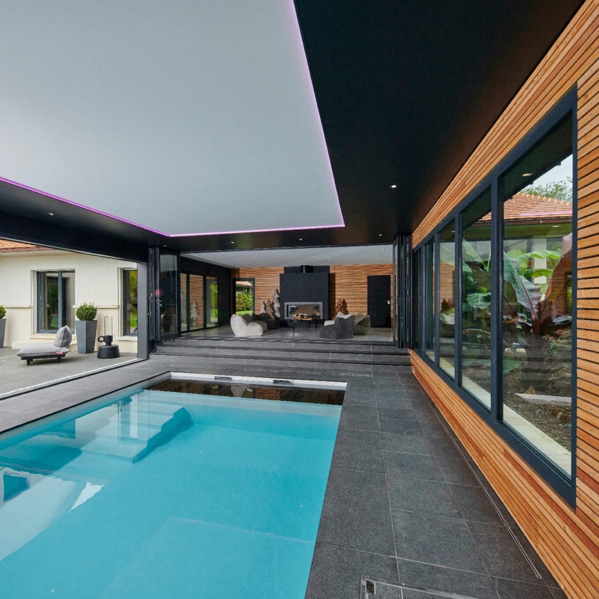 Piscine intérieure de 11 x 4m à fond plat. Volet immergé caillebotis immergé en bois exotique Ipé