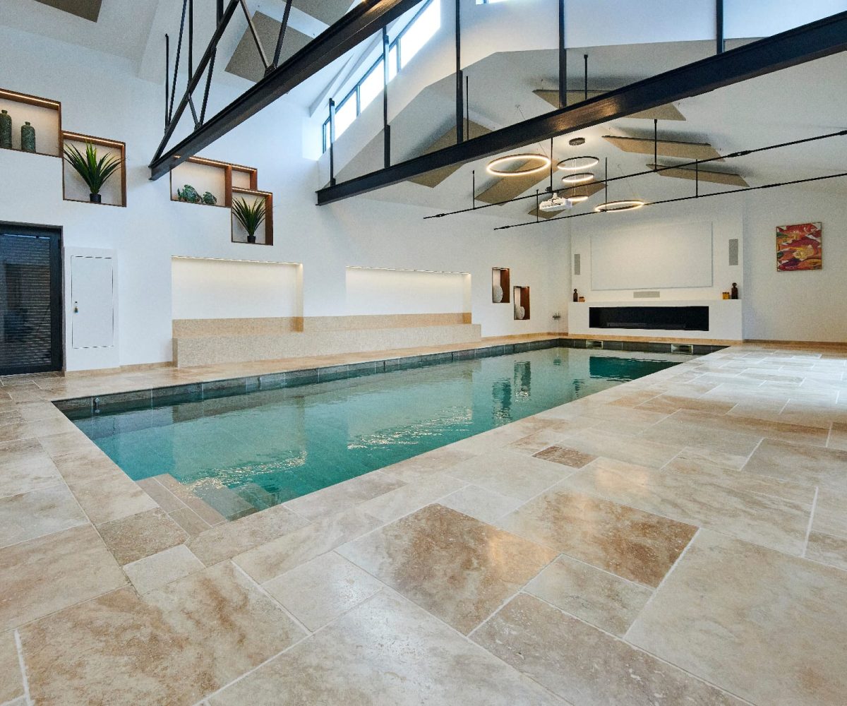 Piscine intérieure carrelée de 12 x 4m avec fond mobile qui fait disparaitre totalement la piscine une fois refermé